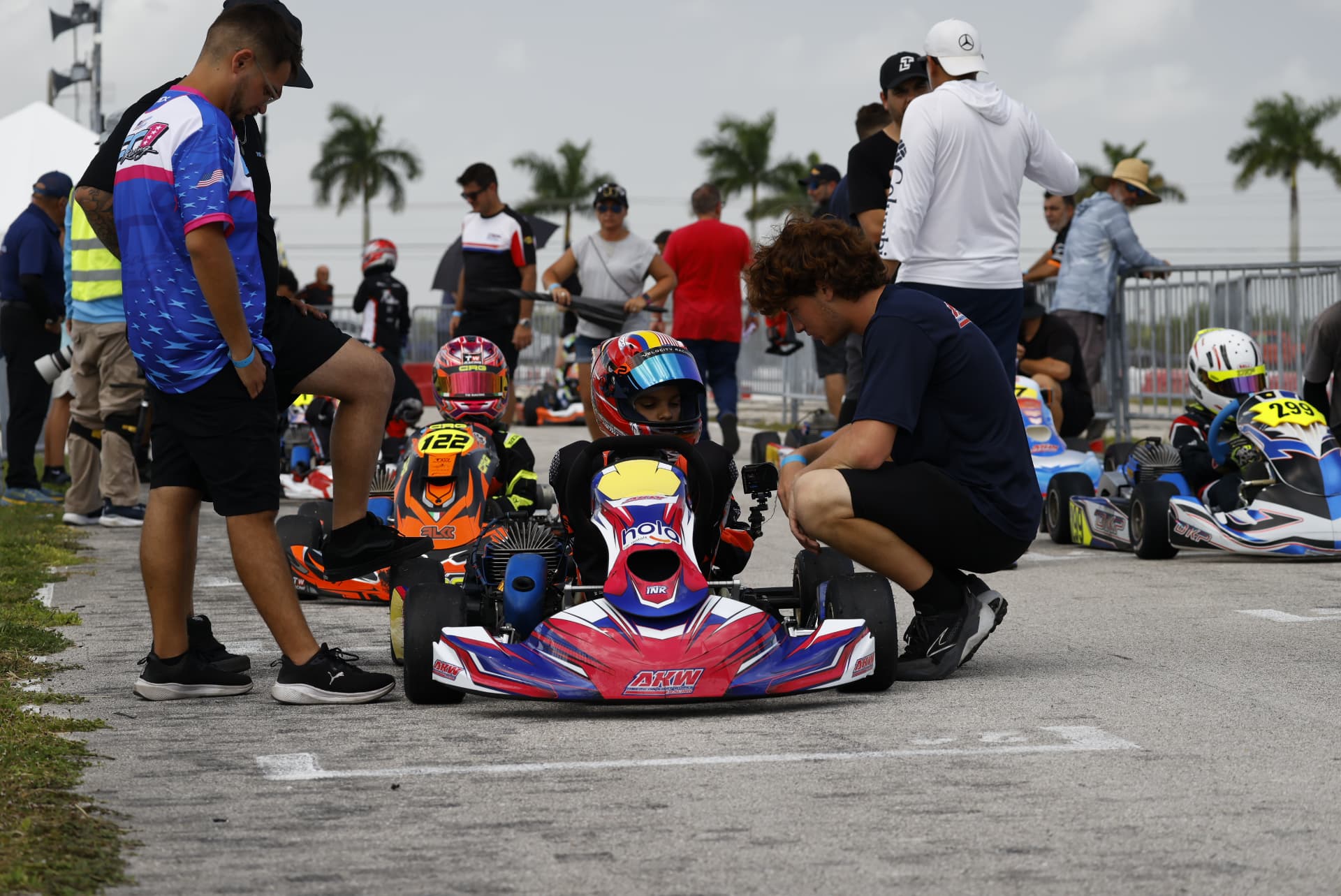 Junior drivers and coaches preparing karts on the grid